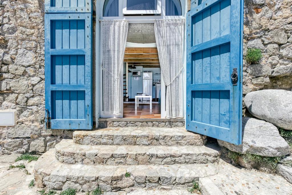 an entrance to a stone house with blue doors at Loft Calella de Palafrugell in Calella de Palafrugell