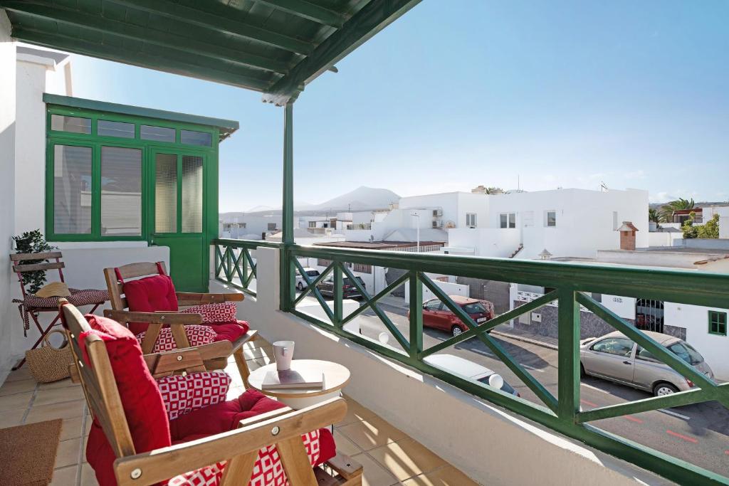 a balcony with chairs and a view of a city at Los Alisios del Patron in Playa Honda