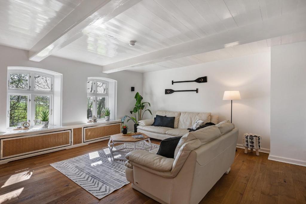 a living room with a couch and a table at Knutzenswarft - Deichgraf in Westerhever