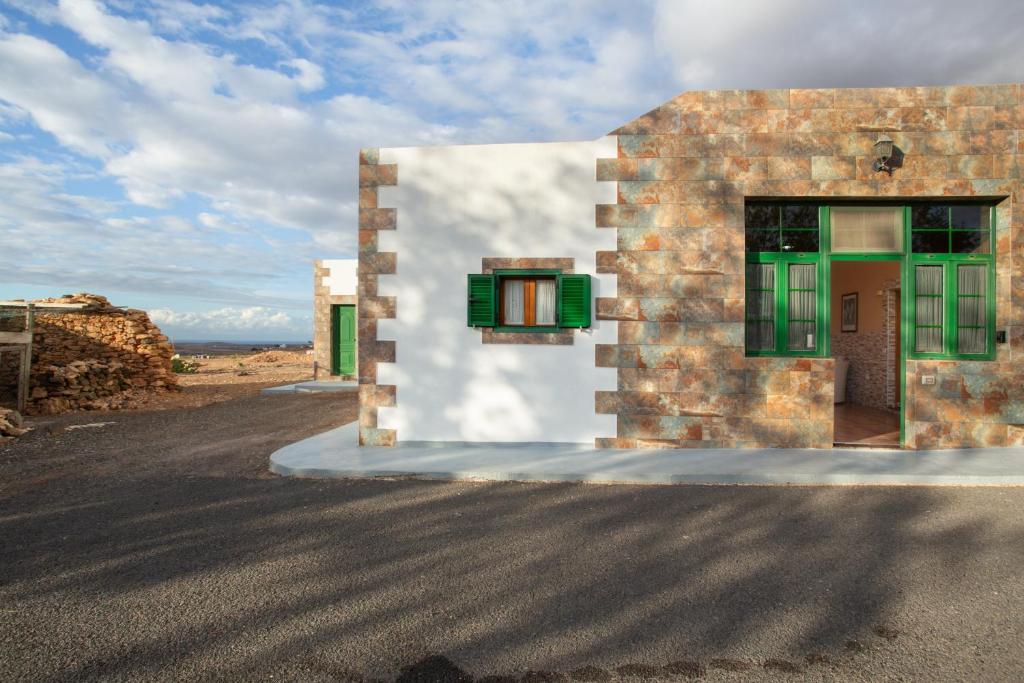 a building with green windows on the side of a road at Casa Dayaday in Puerto del Rosario