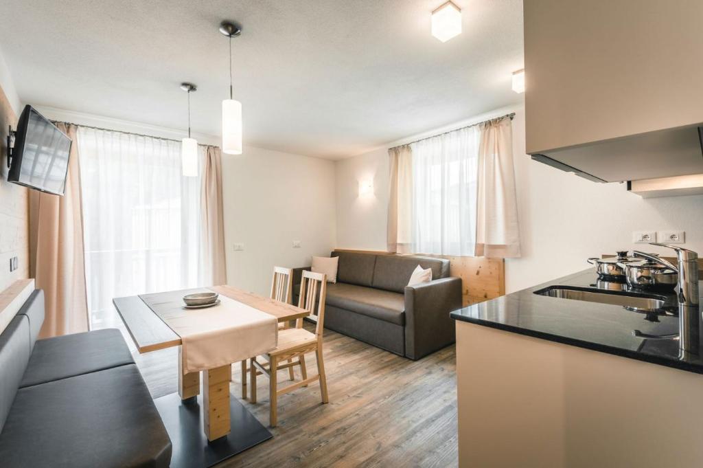a kitchen and living room with a couch and a table at Chalet La Flüta Primula in La Valle