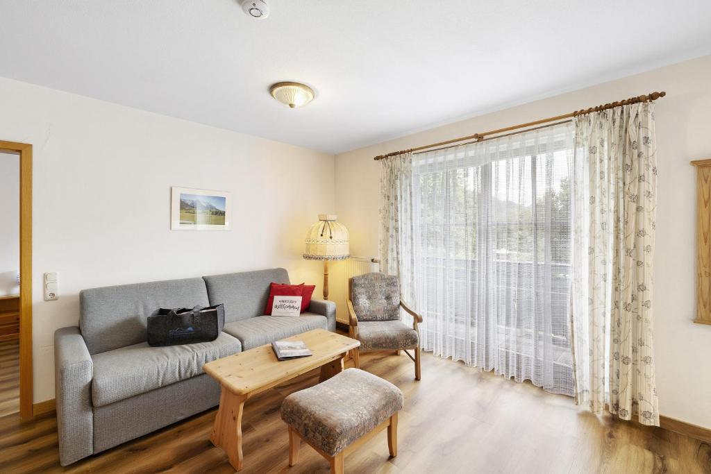 a living room with a couch and a chair at Fewo Brünnstein - Nr 44 Pool, Sauna in Oberaudorf