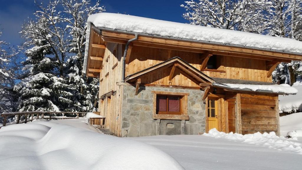 a log cabin covered in snow in the woods at Morzine Panoramic in Morzine