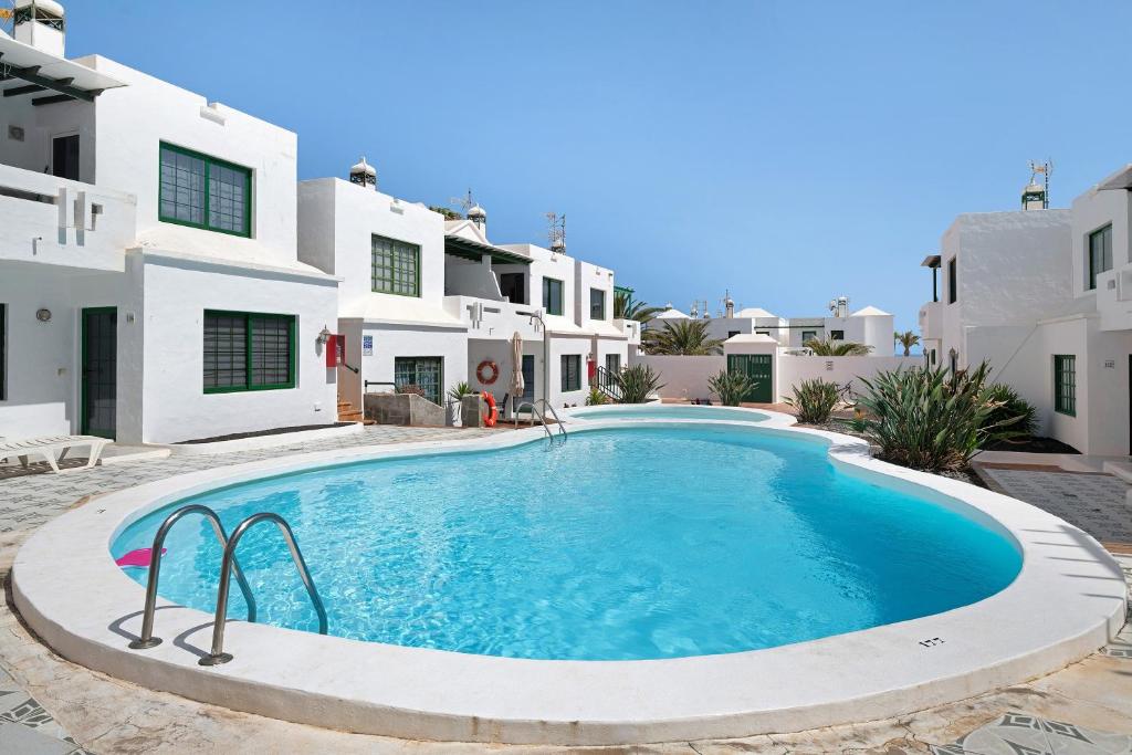a swimming pool in front of a villa at Noaian in Puerto del Carmen