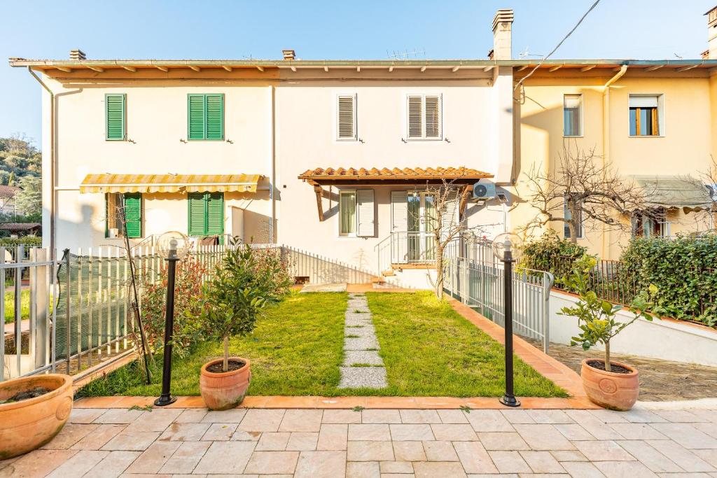 a white house with a fence and a yard at Holiday House Giuliana in Poggio a Caiano