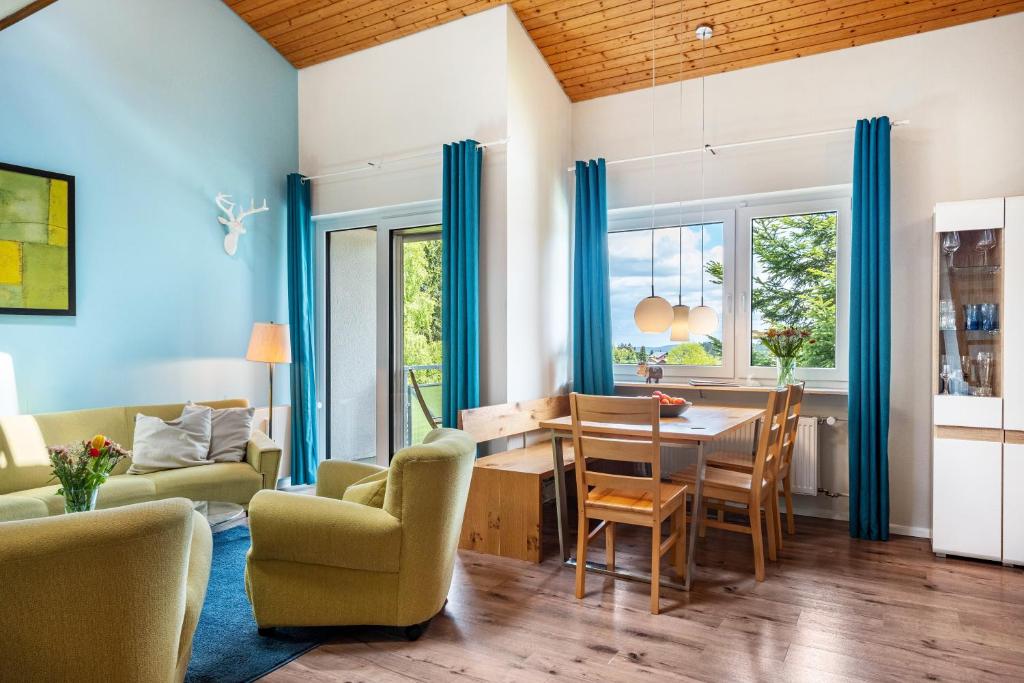 a living room with a dining room table and chairs at Himmelblau in Schönwald