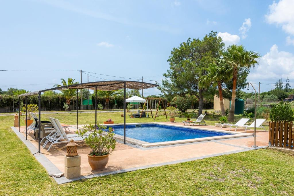 a swimming pool in a yard with a pavilion at Finca Kelly in Artá