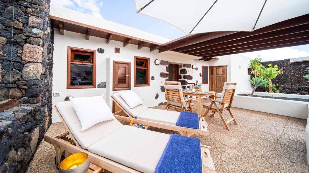 a patio with two lounge chairs and a table at Casa Margarita 4 in Mala