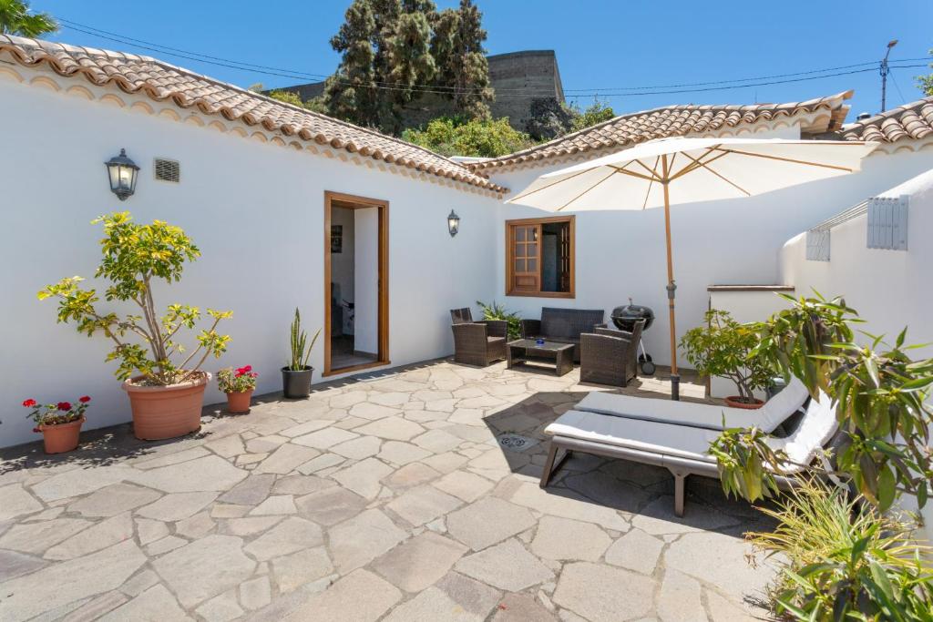 a patio of a house with an umbrella at Volcán 18 in Tanque