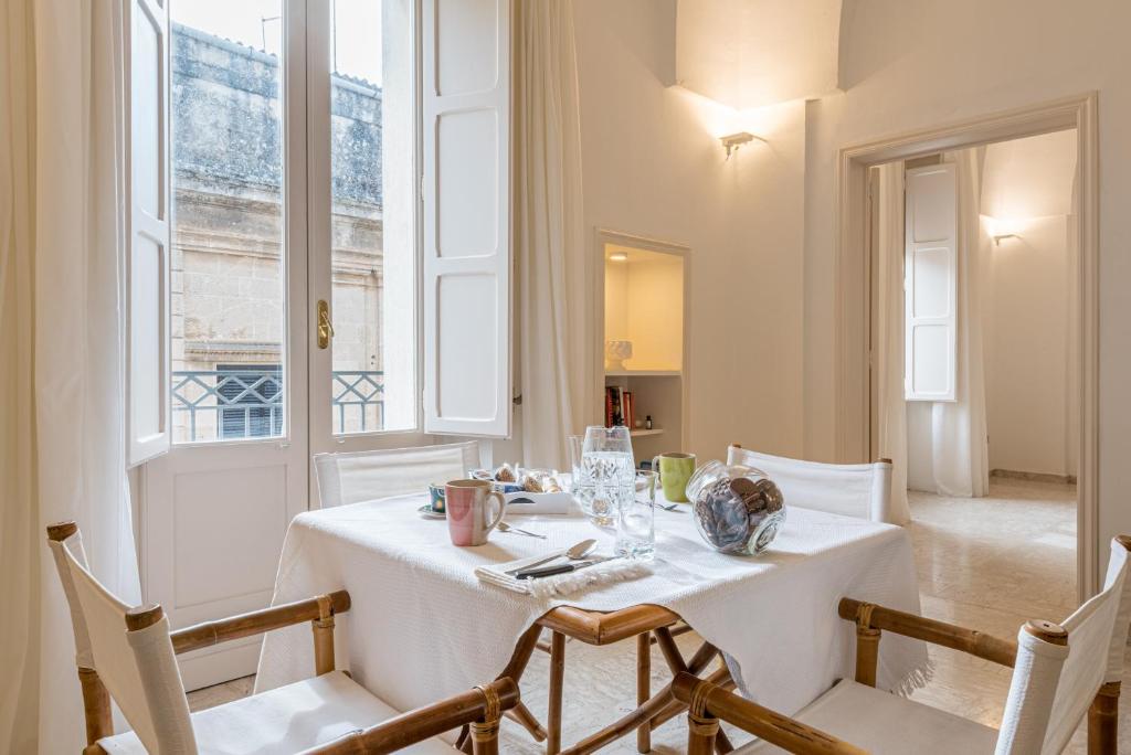 a dining room with a white table and chairs at Dimora Cece in Francavilla Fontana