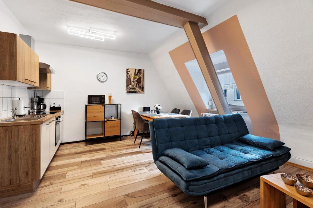 a living room with a blue couch and a kitchen at Casa Doro in Donaueschingen