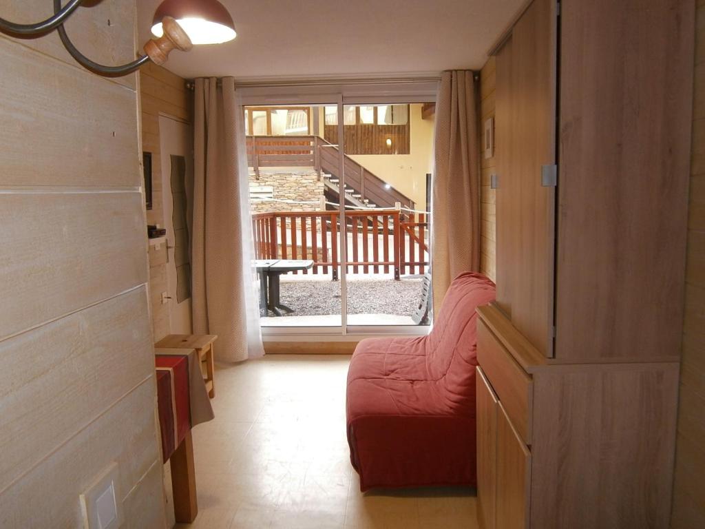 a hallway with a red couch and a sliding glass door at Appartement Le Relais Du Devoluy in Le Dévoluy