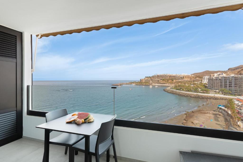 a balcony with a table and a view of the ocean at Ocean wave retreat in Patalavaca