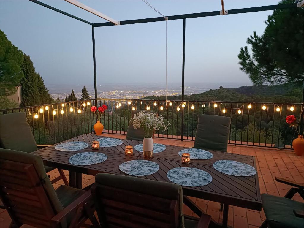 a wooden table with chairs and lights on a patio at Sombrero Cordobé in Córdoba