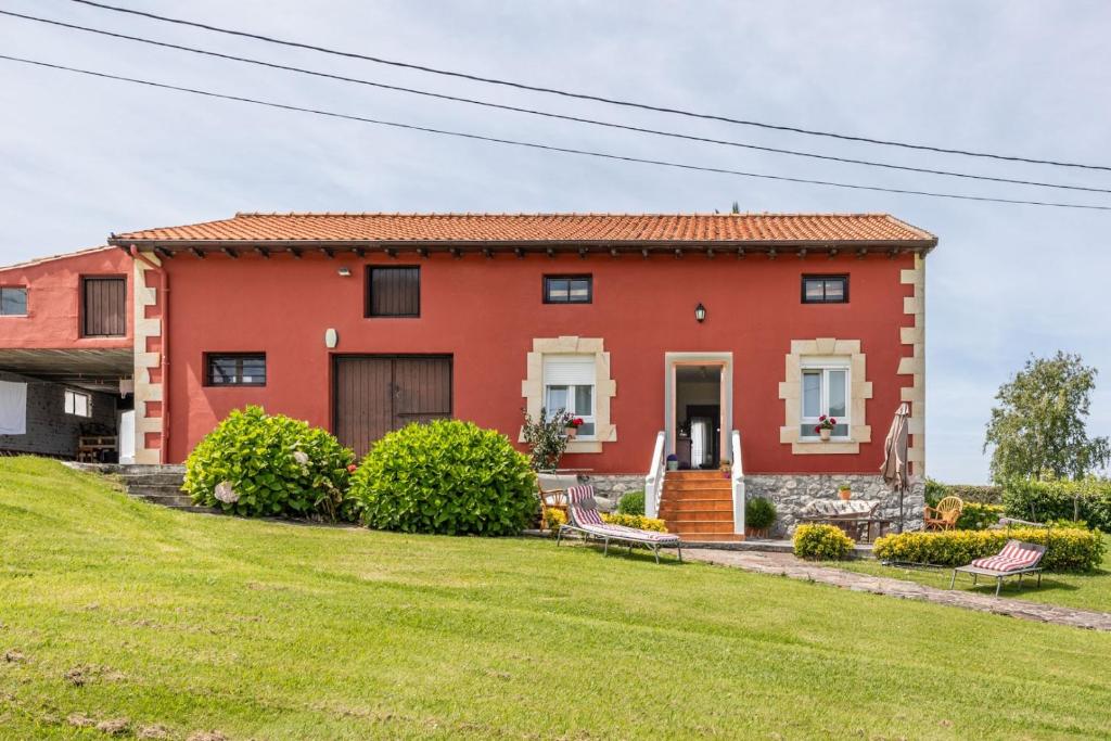 a red house with a yard at Brizna in Oreña