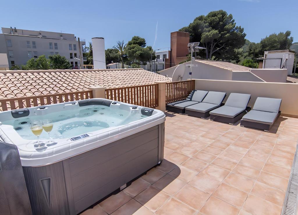 a hot tub on a patio with three chairs at Pescadores in Cala Ratjada