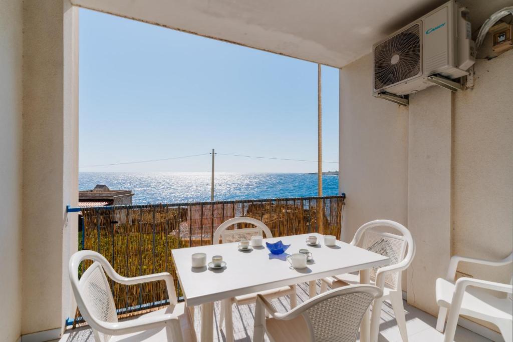 a white table and chairs on a balcony with a view of the ocean at Olimpia's home in Otranto in Otranto