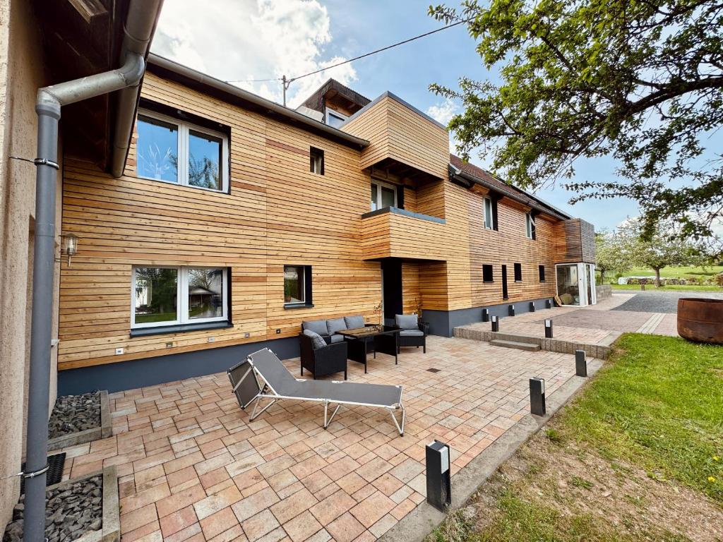 a house with a bench in front of a building at Lot54 Holiday Homes in Feuerscheid
