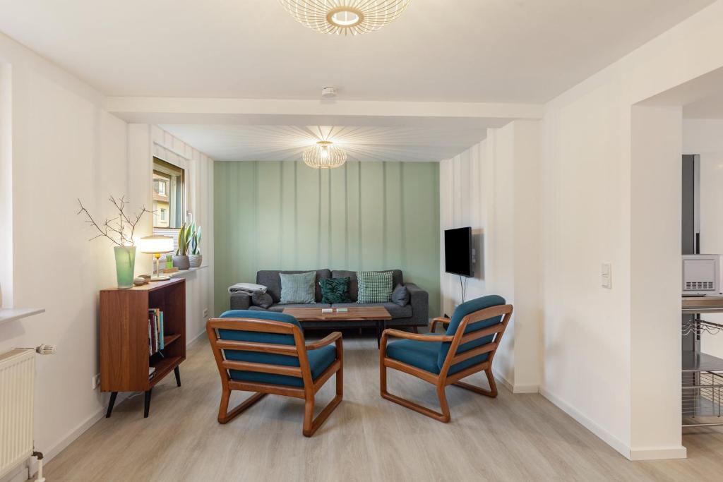 a living room with a couch and two chairs at Höhe26 in Bad Vilbel