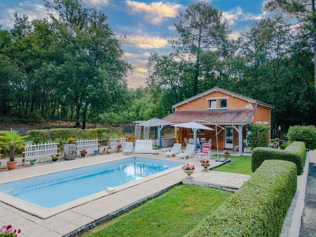 a swimming pool in a yard with a house at La Villa du Mas des Chenes in Pomport