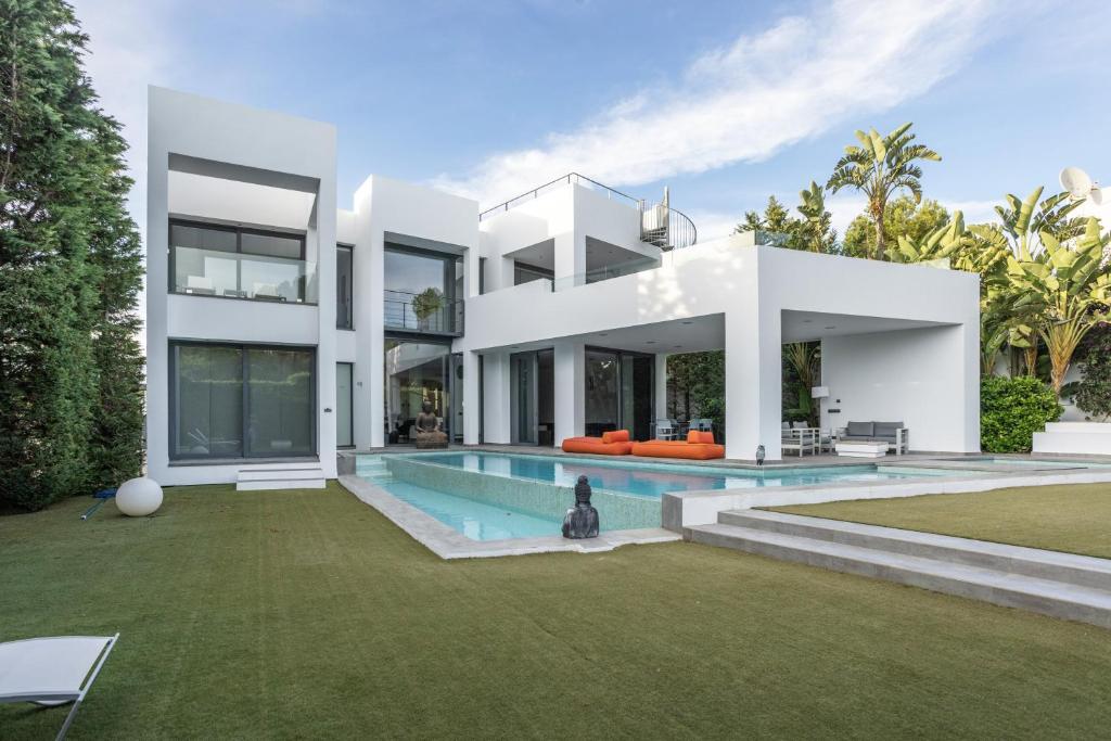 a large white house with a swimming pool at Villa Elite Maribiza in Cala Llena