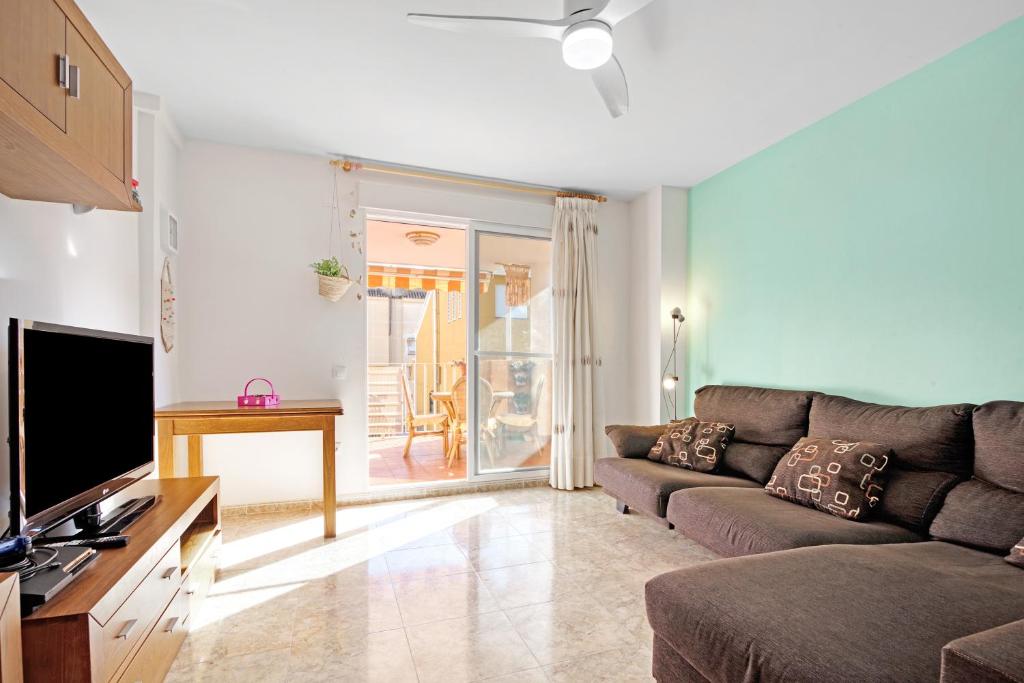a living room with a couch and a television at Playa de Chilches in Chilches