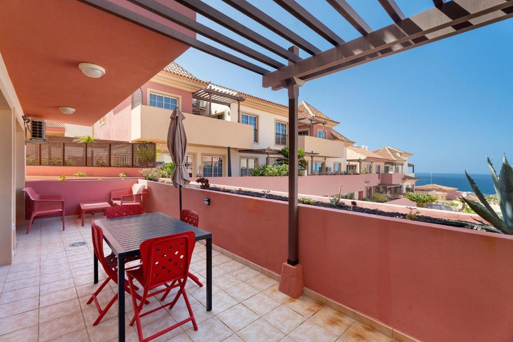 a patio with a table and chairs and a view of the ocean at terrazas del duque fase2 in Adeje