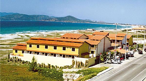 un edificio al lado de una carretera junto a la playa en Praia das Dunas Residence Club, en Cabo Frío