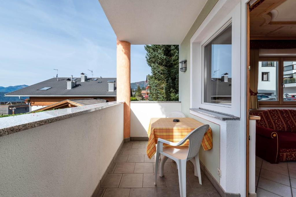 a table and chair on a balcony with a window at Residence Diana Apartment 103 in Terento