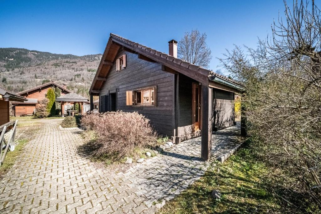 a black house with a brick driveway in front of it at Chalet 6p Confort - Le Morlay in Verchaix