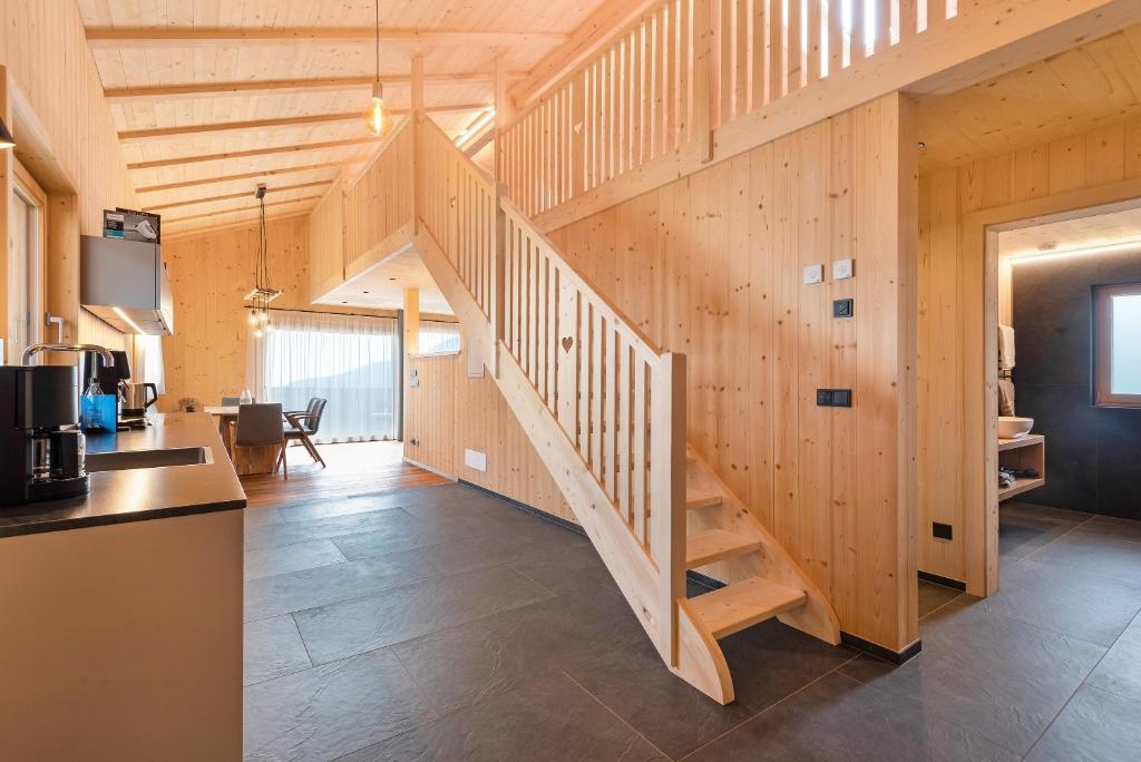 a wooden staircase in a home with a living room at Ratscheinerhof App Waldruhe in Lazfons