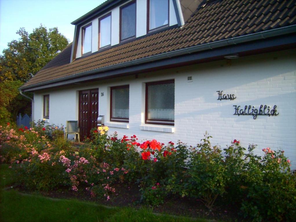 a white house with flowers in front of it at Haus Halligblick in Dagebüll