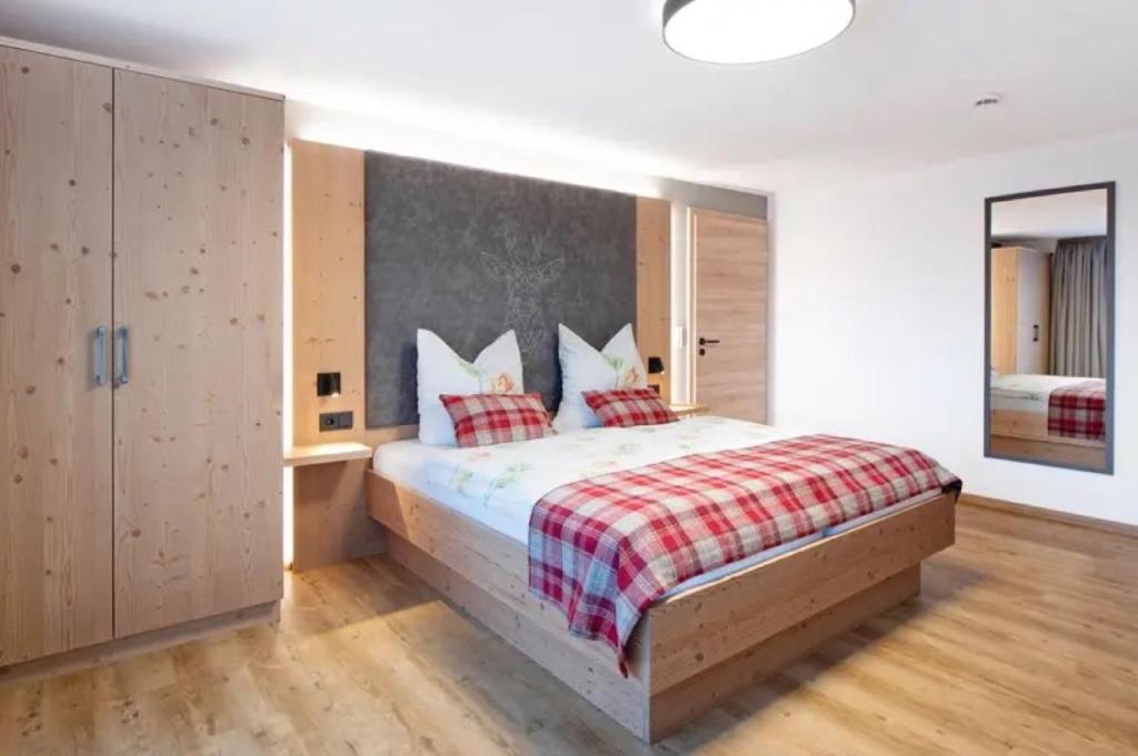 ein Schlafzimmer mit einem Bett mit einer rot-weißen Decke in der Unterkunft Kaiserchalet in Höchenschwand