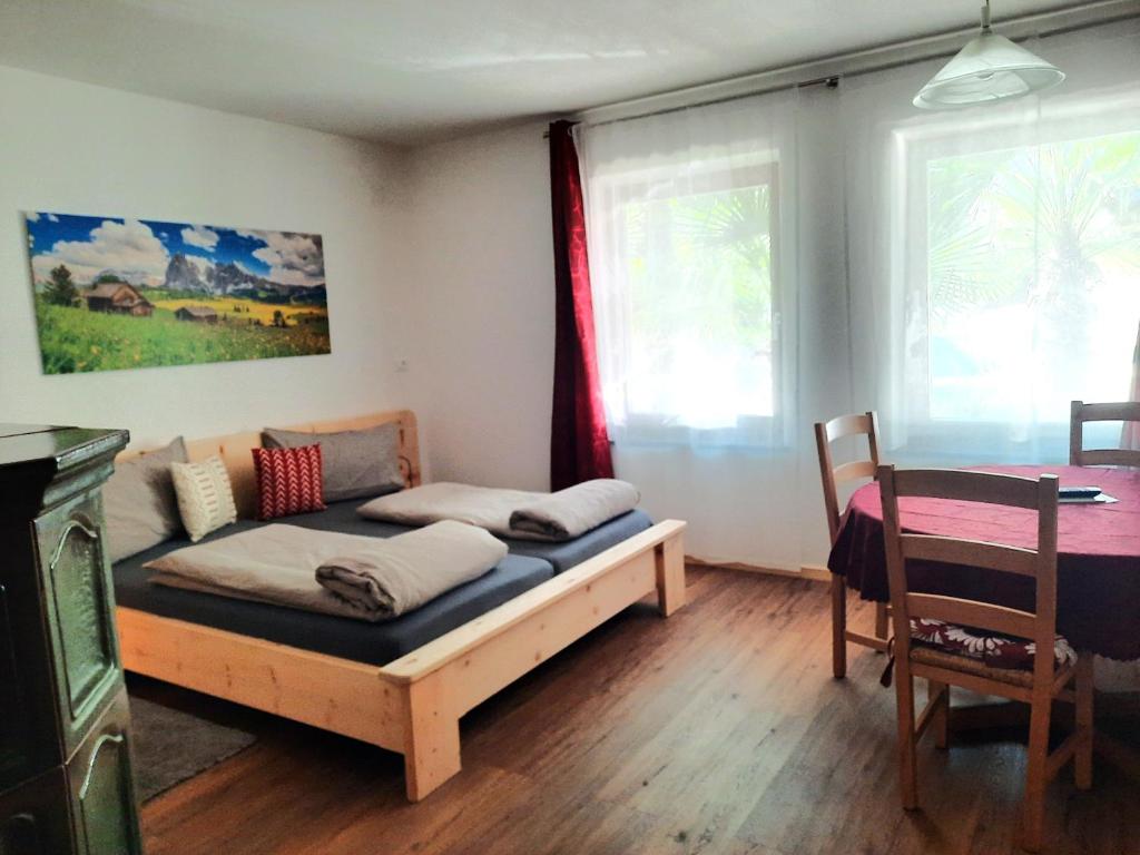 a bedroom with a bed and a table and window at Peter Paul Domblick Erdgeschoss in Appiano sulla Strada del Vino