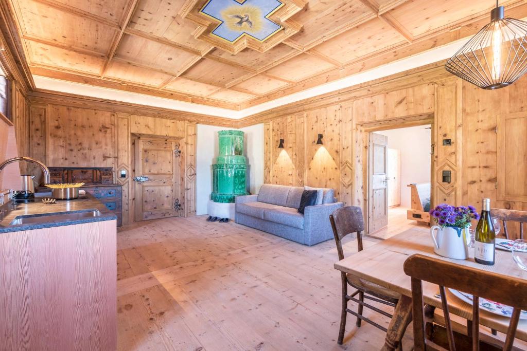 a kitchen and living room with a couch and a table at Hof im Thal Apt Zirbe in Aldino