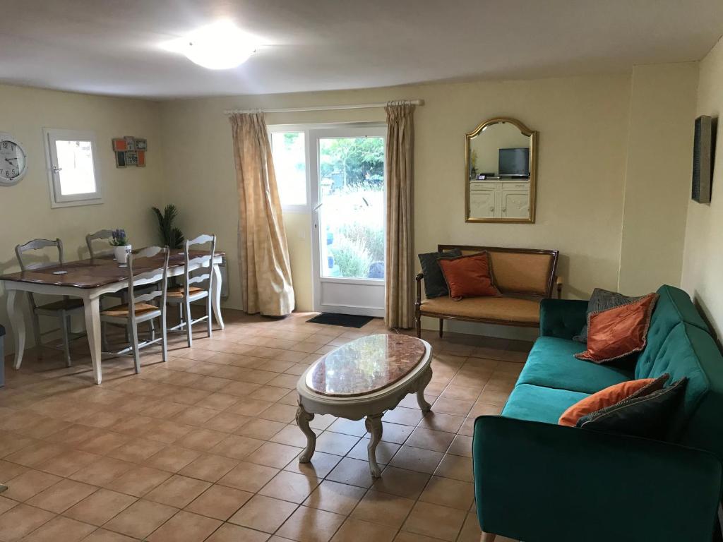 a living room with a green couch and a table at Gite Le Lot in Bias