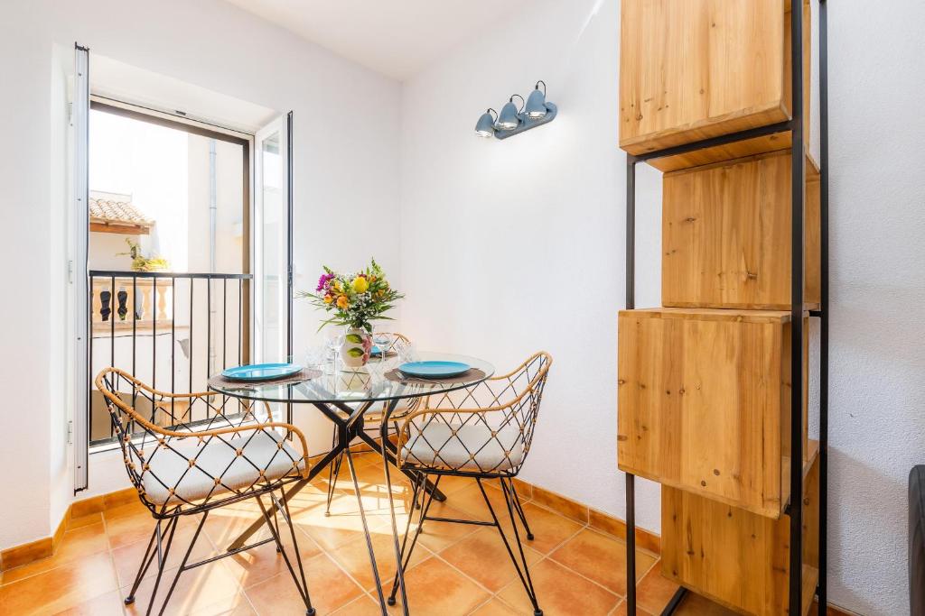 a table and chairs in a room with a balcony at Apartamento Can Jaume in Artá