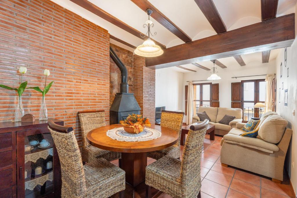 a living room with a table and chairs and a brick wall at Cueva Del Gollisno in Chulilla