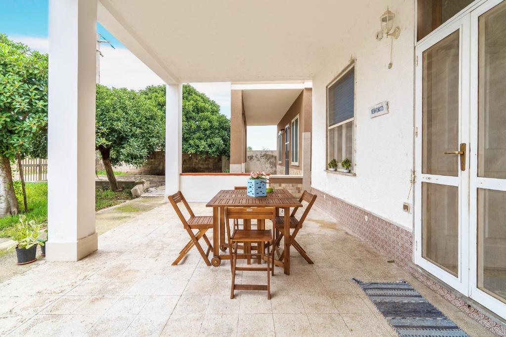 a patio with a wooden table and chairs at Villetta Granelli in Granelli