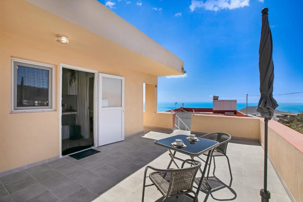 a patio with a table and chairs and an umbrella at Fewo Arafo in Güimar