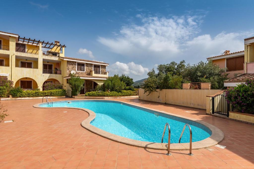 a swimming pool in front of a building at Appartamento Isabel in Villasimius