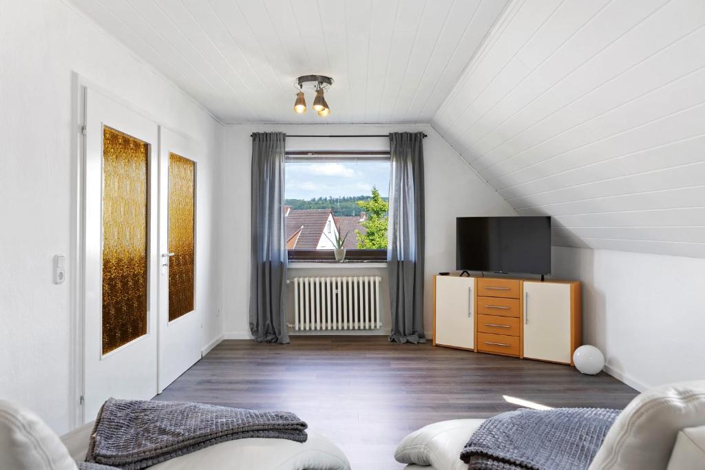 a living room with a couch and a tv at Ferienwohnung en Verde in Felsberg