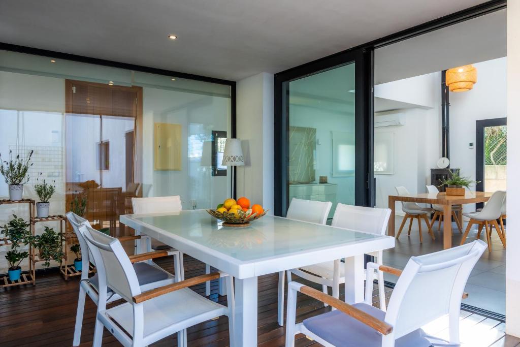 a dining room with a white table and white chairs at Es Nautic in Porto Cristo