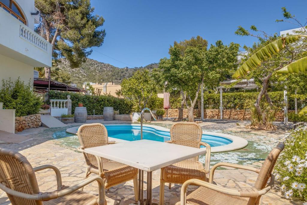 a patio with a table and chairs next to a swimming pool at La Cabanya Apartment 3d in Canyamel