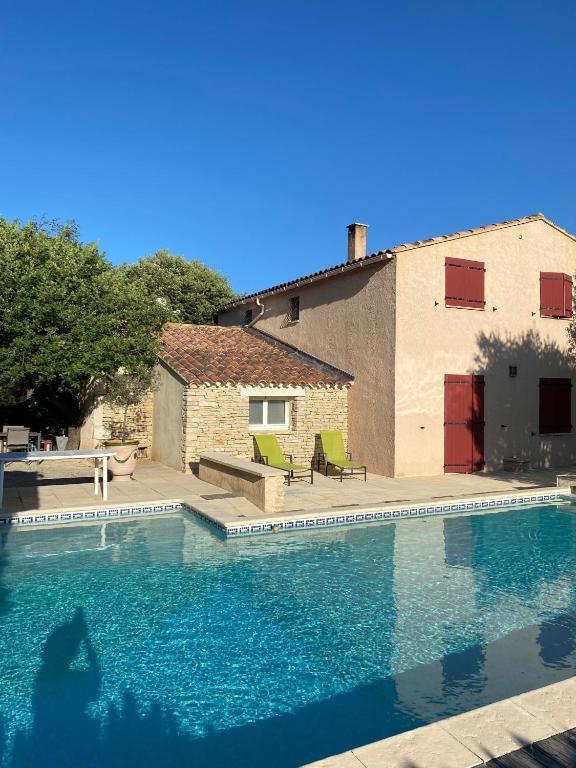 a swimming pool in front of a house at Mas Les Coutilles in Cabrières-dʼAvignon