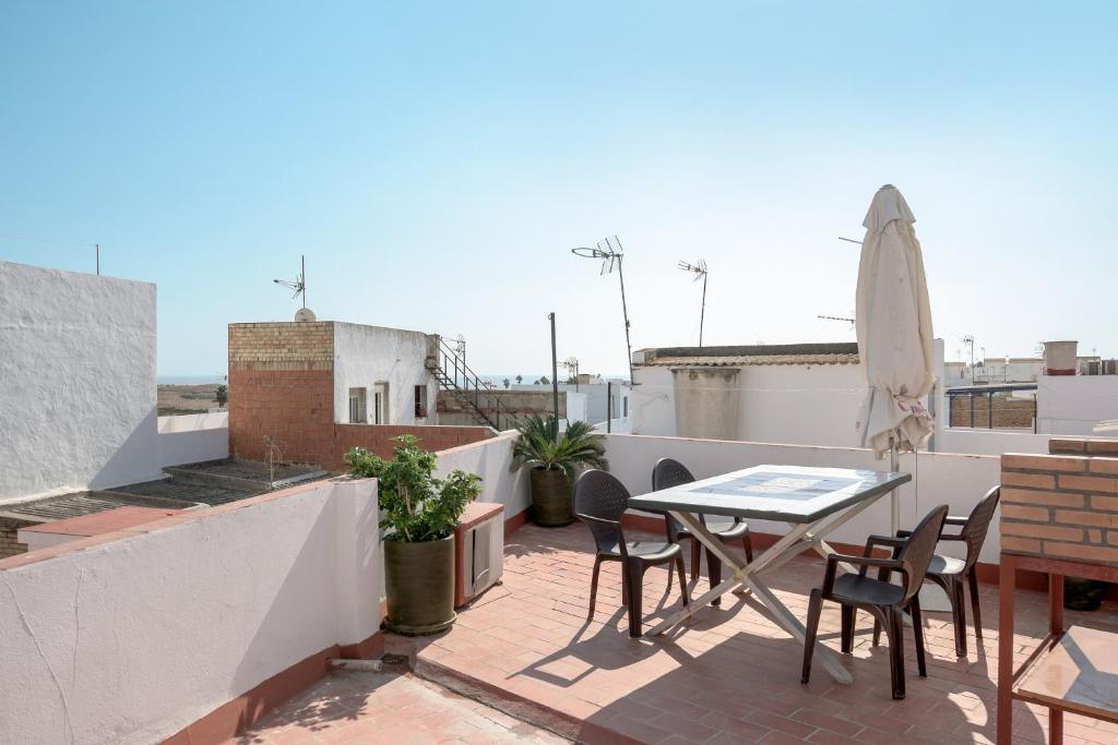 a patio with a table and chairs on a roof at Piso Río de Conil in Conil de la Frontera