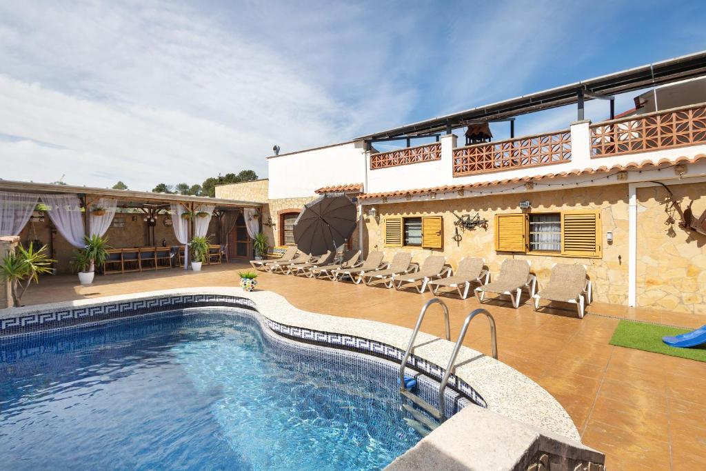 a villa with a swimming pool in front of a house at Cal Ramon con piscina in Rubí