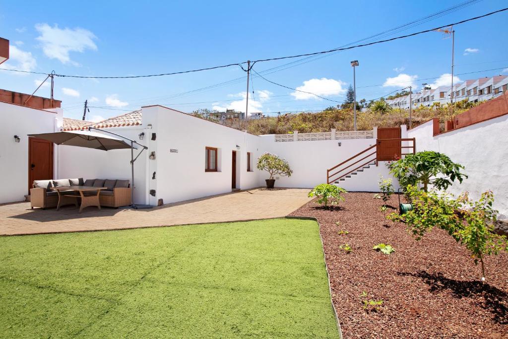 a white house with a patio and grass at Casa Marhec in Sauzal