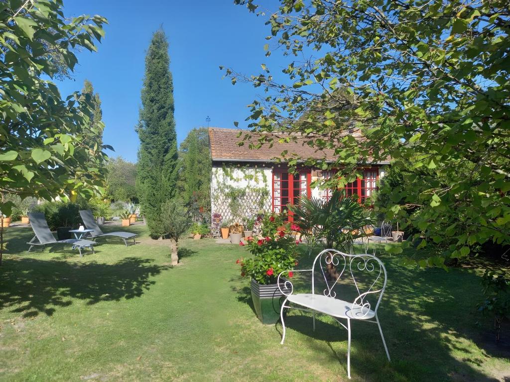 a garden with a bench and a house at Maisonnette Cocooning en Sologne in Gy-en-Sologne