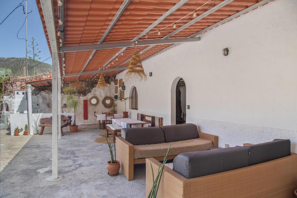 a patio with couches and a table and chairs at Casa Cueva Rural, Calima in Juncalillo